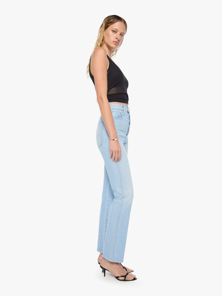 Side view of a woman in a light blue  super high-waisted pants have a button fly, slightly tapered straight leg, a long 32-inch inseam and a clean hem. 