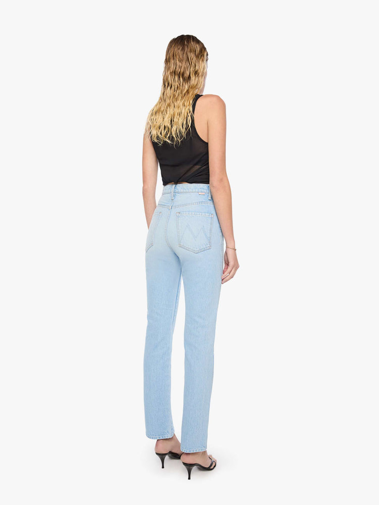 Back view of a woman in a light blue  super high-waisted pants have a button fly, slightly tapered straight leg, a long 32-inch inseam and a clean hem. 