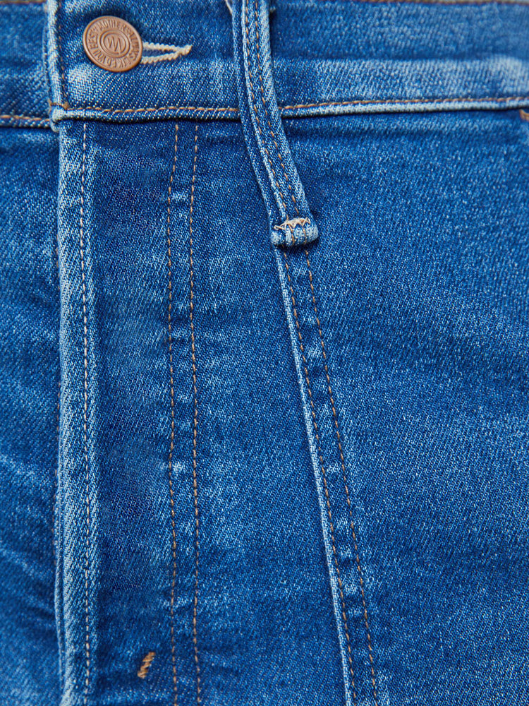 Swatch view of a woman in a mid blue super high-rise jeans with a loose fit, wide leg, zipper-fly, patch pockets and 29-inch inseam with a clean hem.