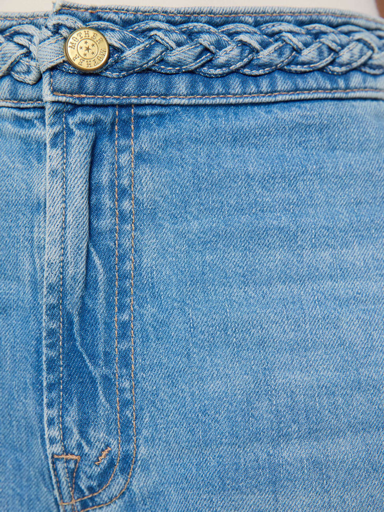 Swatch view of a woman in light blue with braided details along the waist and down the outer seam, wide leg jeans with a high rise, zip fly, 32-inch inseam and a clean hem. 