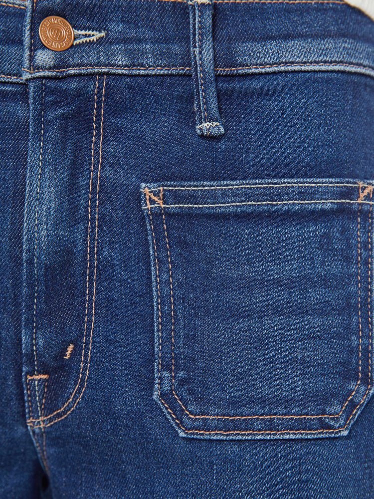 Swatch view of a woman in a dark blue mid-rise jeans with a loose fit, zip fly, wide leg, patch pockets and ankle-length inseam with a clean hem