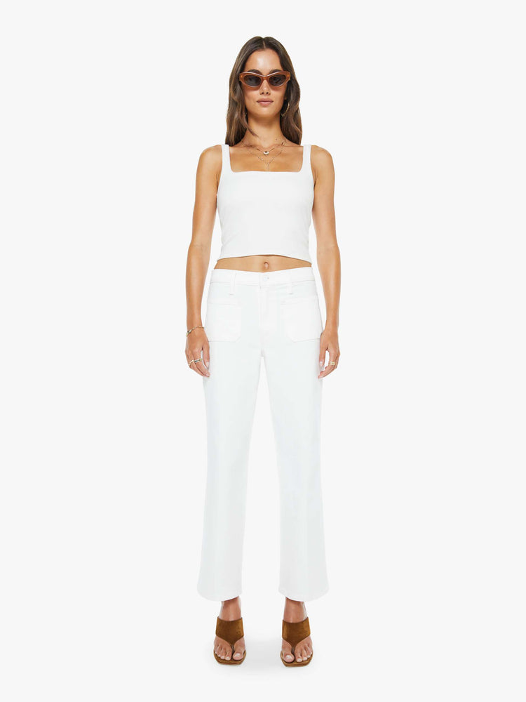 Front view of a woman in a white id-rise jeans with a loose fit, zip fly, wide leg, patch pockets and ankle-length inseam with a clean hem.