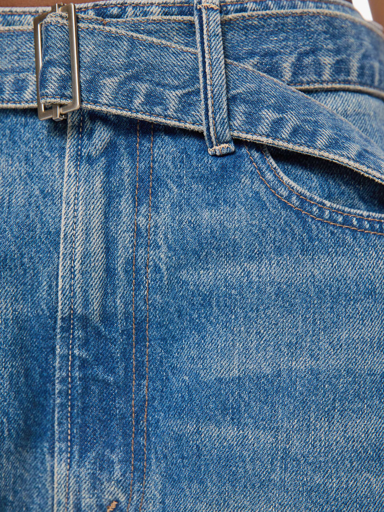 Swatch view of a woman in a mid blue wide leg super high-waisted jeans are designed with a belted waistband, zip fly, an inset panel on the outer seam, slightly tapered leg and a clean hem.