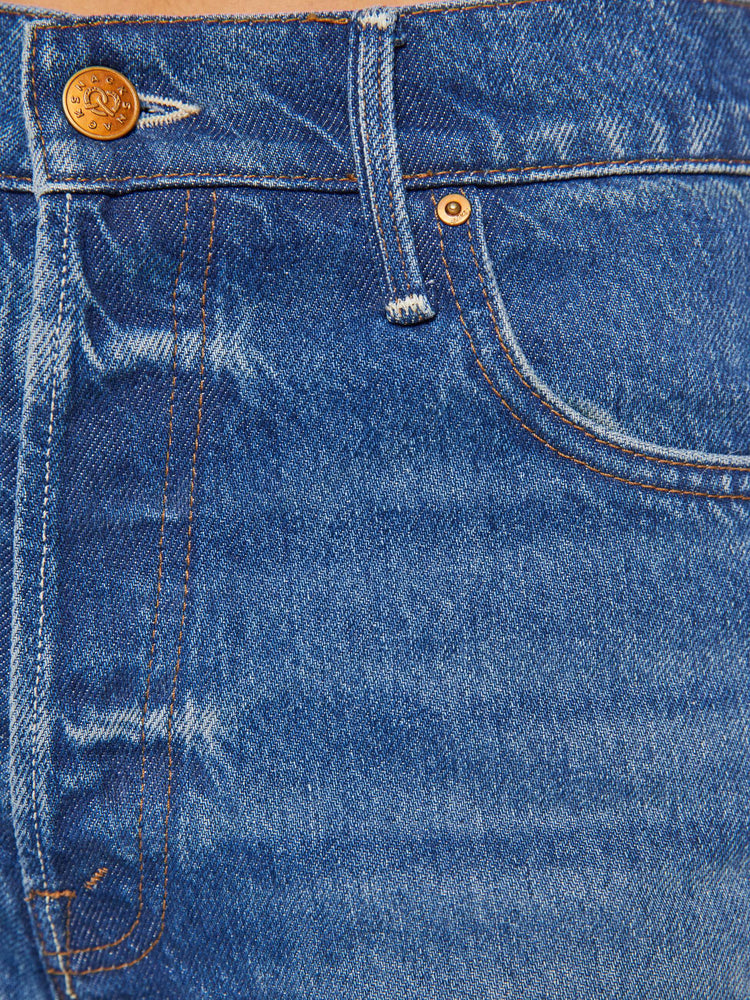 Swatch view of a woman in mid blue wide straight-leg jeans designed to sit on the hips with a slouchy fit, button-fly and a long 31-inch inseam with a cuffed hem.