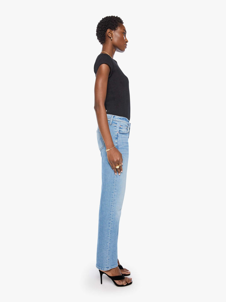 Side view of a woman in light blue  lower-rise bootcut with a zip fly, 31-inch inseam and a clean hem. 