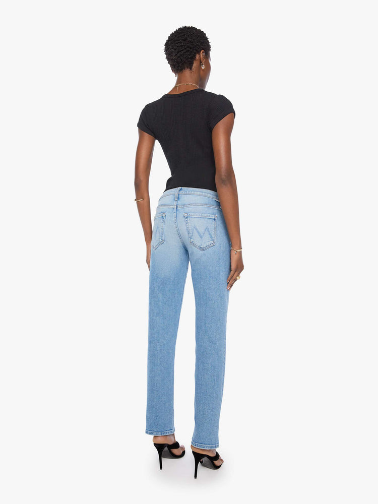 Back view of a woman in light blue  lower-rise bootcut with a zip fly, 31-inch inseam and a clean hem. 