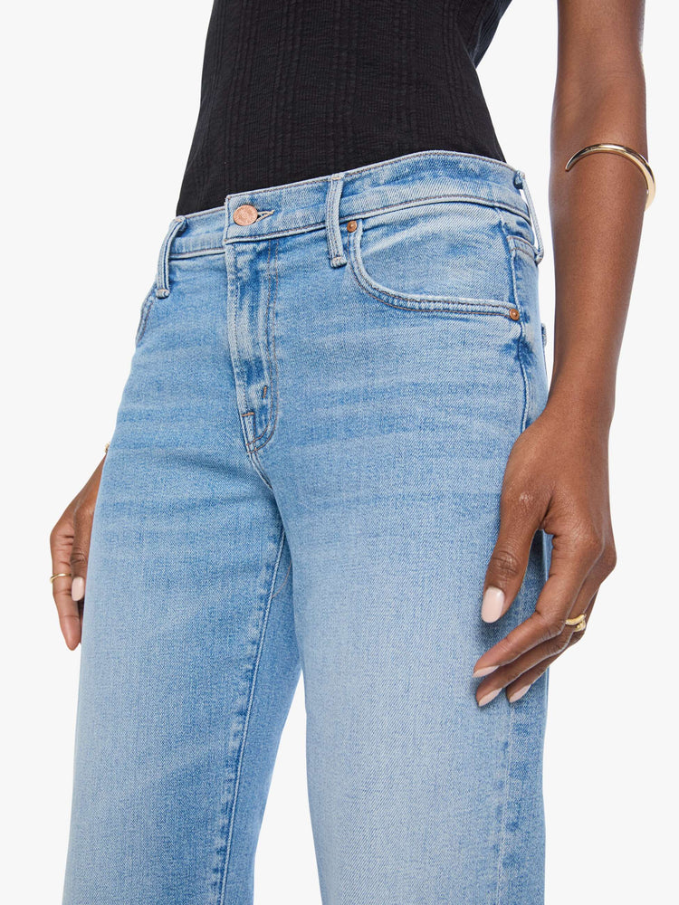 Close up view of a woman in light blue  lower-rise bootcut with a zip fly, 31-inch inseam and a clean hem. 