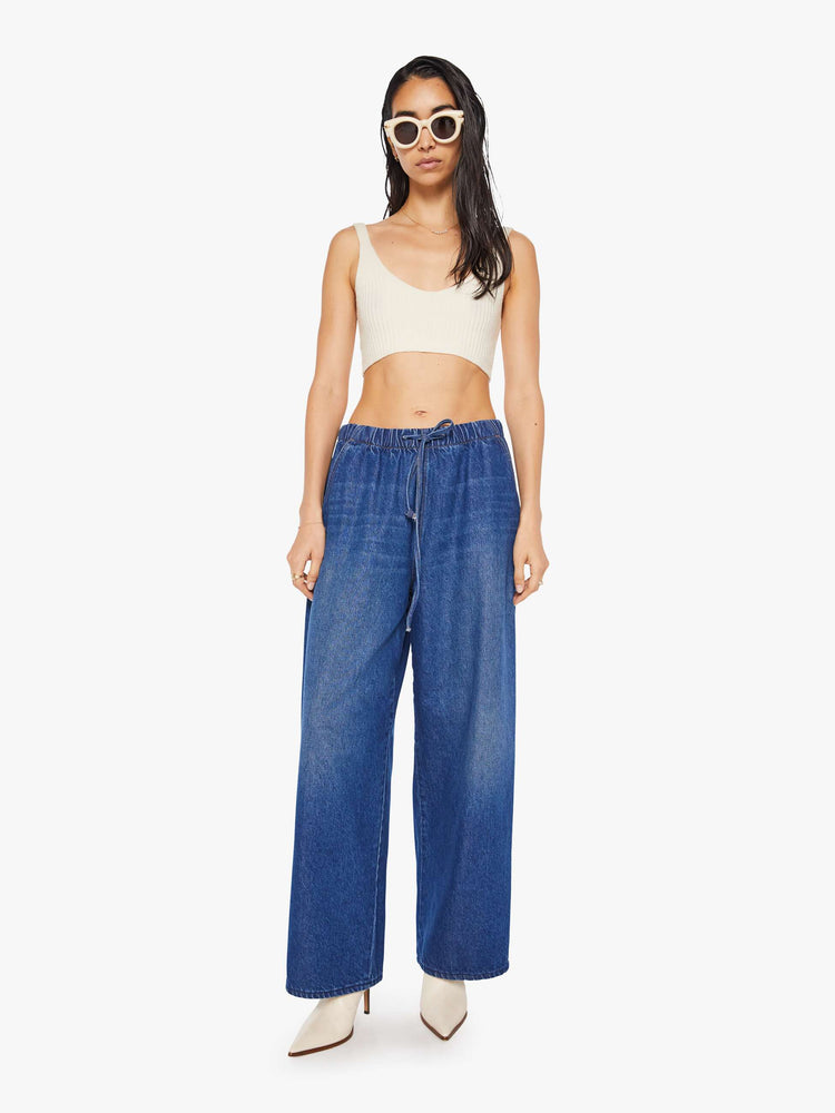 Front view of a woman in a super high-waisted jeans have a loose straight leg, elastic drawstring waistband, zip fly and a 30-inch inseam with a clean hem.