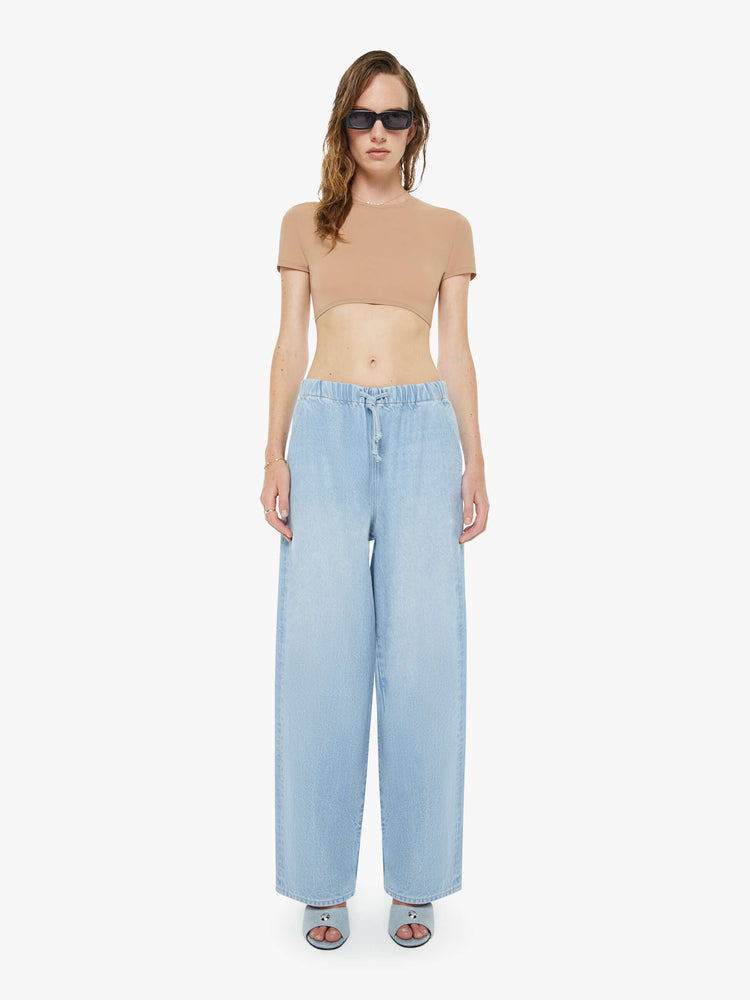 Front view of a woman in a super high-waisted jeans have a loose straight leg, elastic drawstring waistband and a 30-inch inseam with a clean hem. 