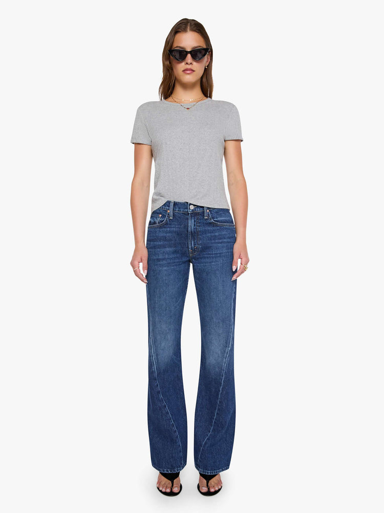 Front view of woman in a mid-rise bootcut with a zip fly, looser leg, twisted outer seam and a long 32-inch inseam with a clean hem.