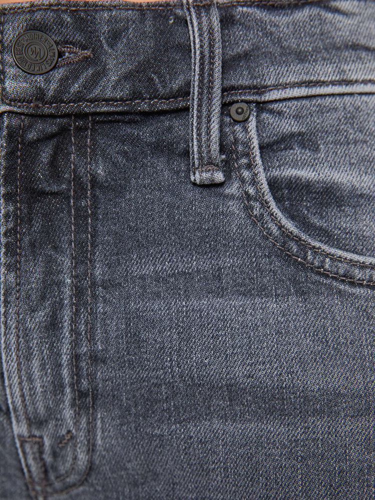 Swatch view of a woman in a washed grey mid-rise bootcut with a zip fly, looser leg, twisted outer seam and a long 32-inch inseam with a clean hem.