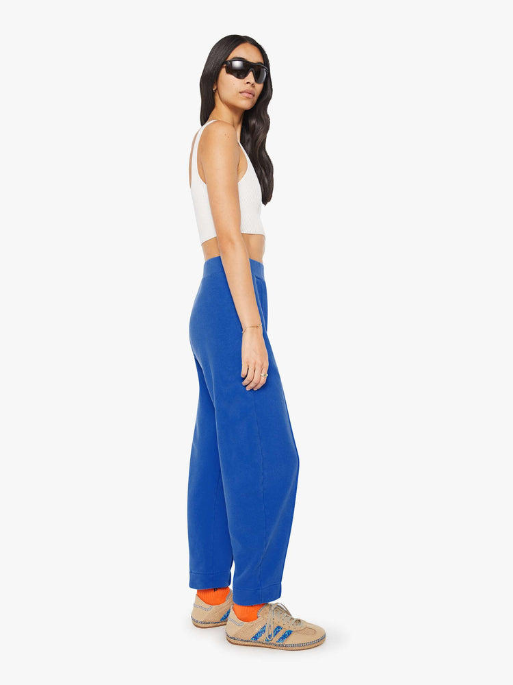 Side view of a woman in bright blue with colorful embroidery at the thigh barrel-leg sweatpants with an elastic waistband, pintuck details and a 28.25-inch inseam.