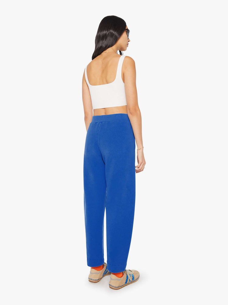 Back view of a woman in bright blue with colorful embroidery at the thigh barrel-leg sweatpants with an elastic waistband, pintuck details and a 28.25-inch inseam.