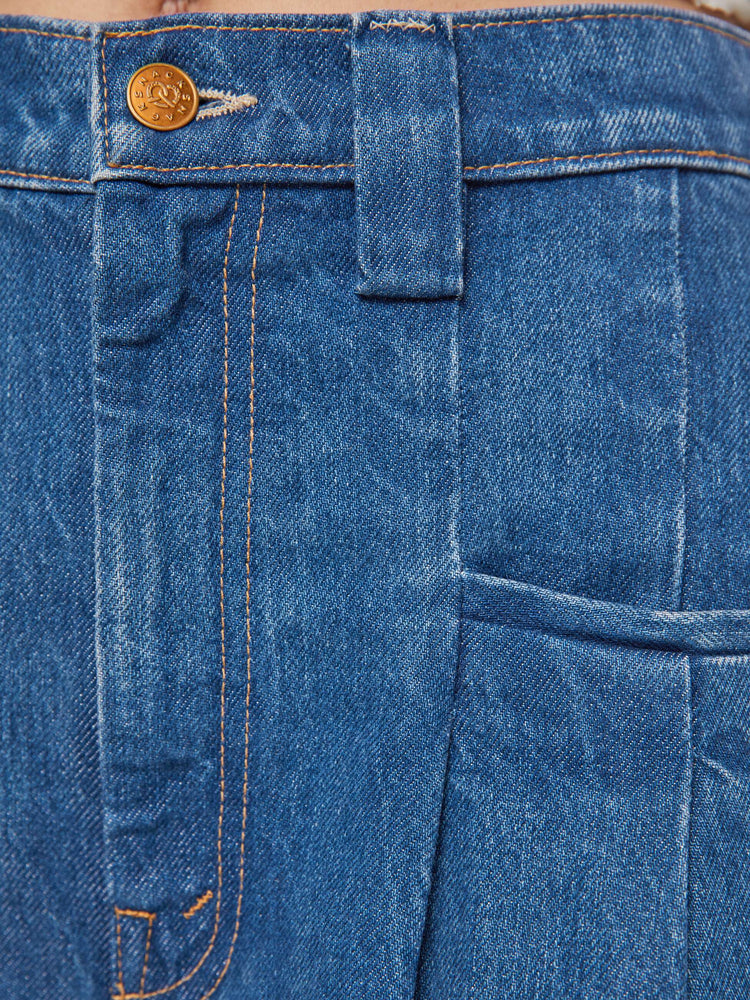 Swatch view of a woman in a super high rise wide-leg jeans are designed with slit pockets, pleated details, a zip fly and a long 31-inch inseam with a clean hem.