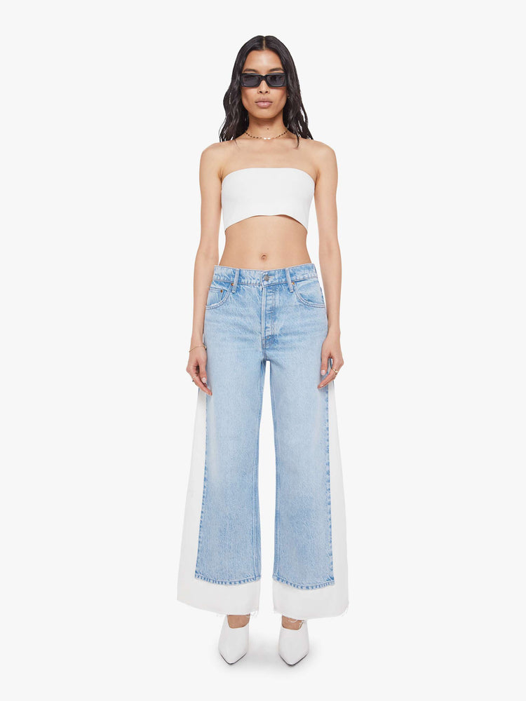 Front view of a woman in light blue high-waisted jeans are designed with a button fly, low-slung fit, 30-inch inseam and a loose wide leg with inset panels on the outer seams.