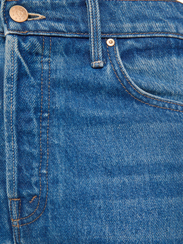 Swatch view of a woman in a mid blue with green panels high-waisted jeans are designed with a button fly, low-slung fit, 30-inch inseam, a loose wide leg with inset panels on the outer seams and a frayed hem.