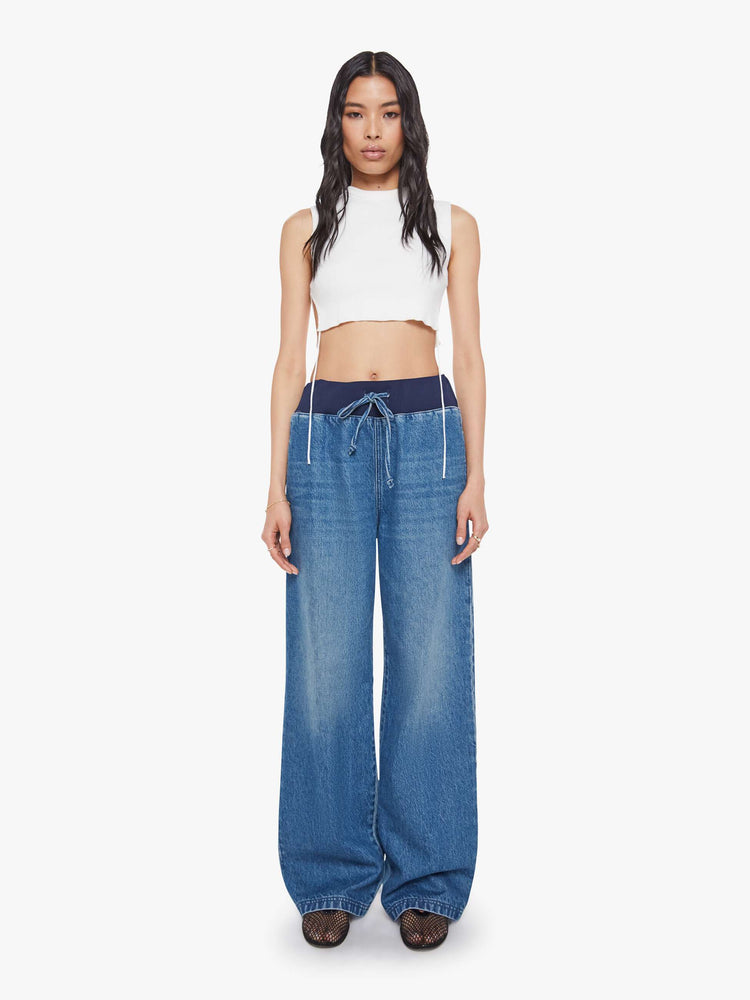 Front view of a woman in a high-waisted wide-leg jeans are designed with a drawstring elastic waistband, slit pockets and a 32-inch inseam with a clean hem.