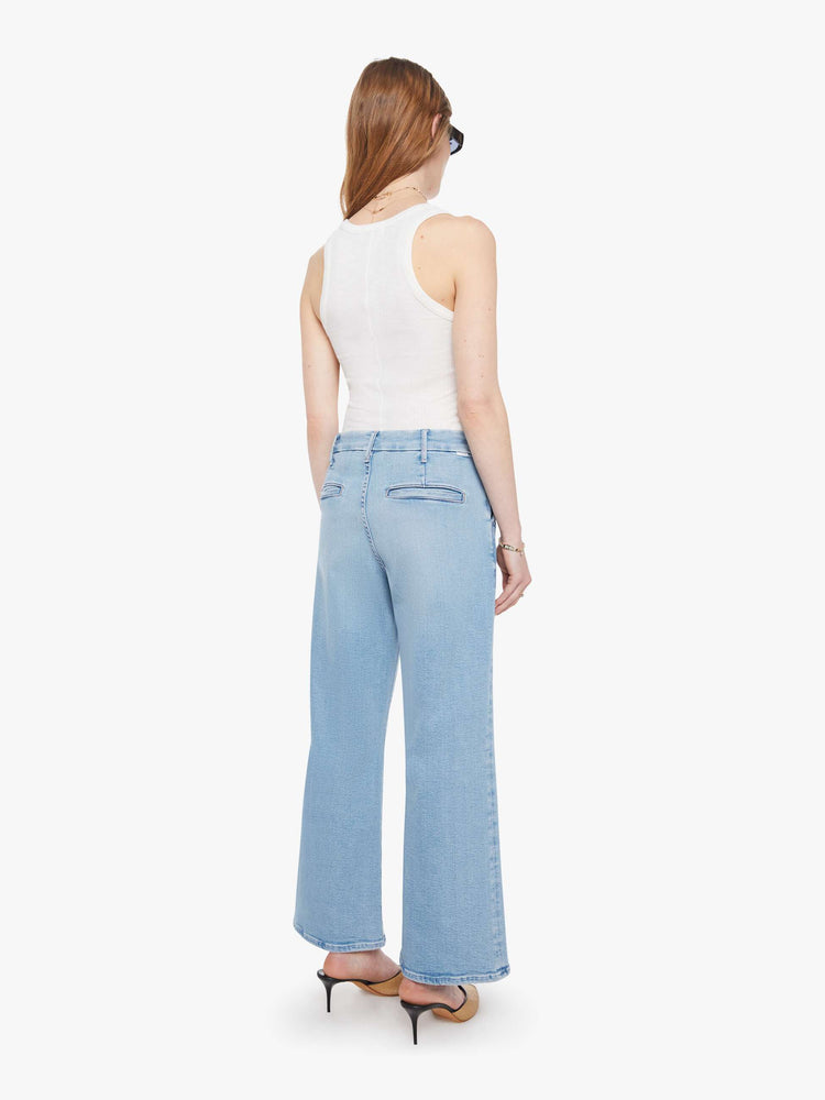 Back view of a woman in wide-leg pants designed to sit lower on the hips with a high rise, slit pockets, a zip fly, relaxed fit and an ankle-length inseam with a clean hem.