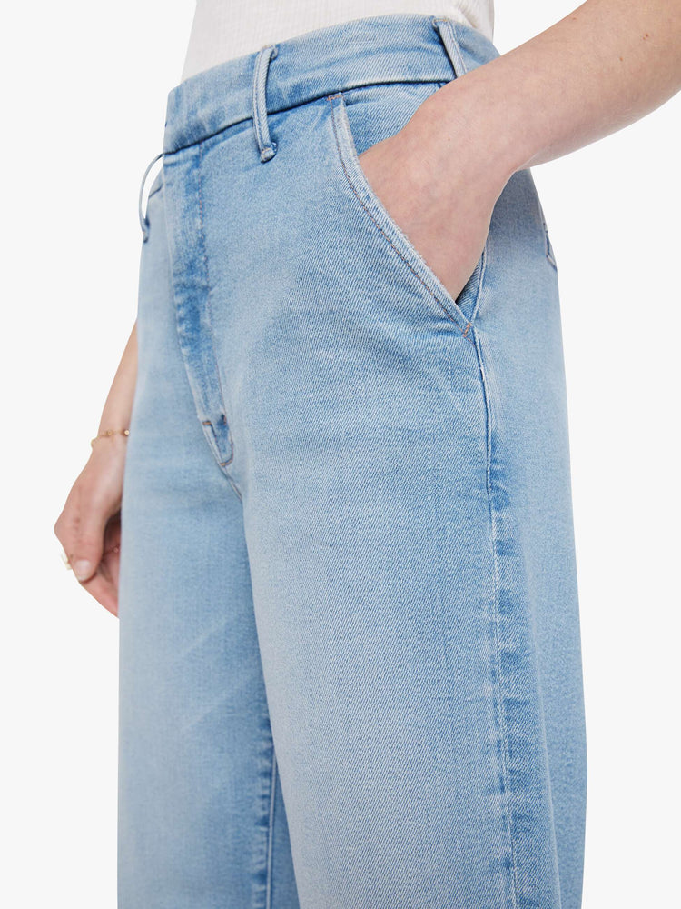 Close up view of a woman in wide-leg pants designed to sit lower on the hips with a high rise, slit pockets, a zip fly, relaxed fit and an ankle-length inseam with a clean hem.