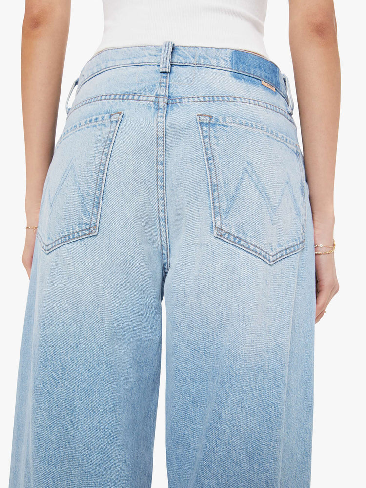 Back view of a woman in jeans designed to sit lower on the hips with a button fly, a 30-inch inseam, clean hem and slightly tapered leg.