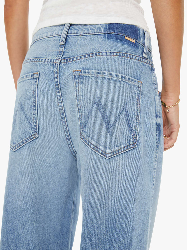 Close up view of a woman in a light blue jeans designed to sit lower on the hips with a button fly, a 30-inch inseam, clean hem and slightly tapered leg.