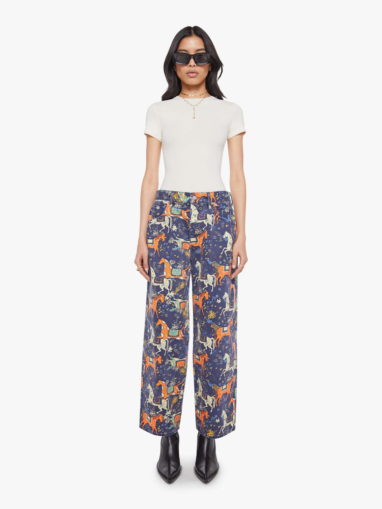 Front view of a woman in navy folk art jeans sit lower on the hips with a long 30-inch inseam, button fly, clean hem and slightly tapered leg. 