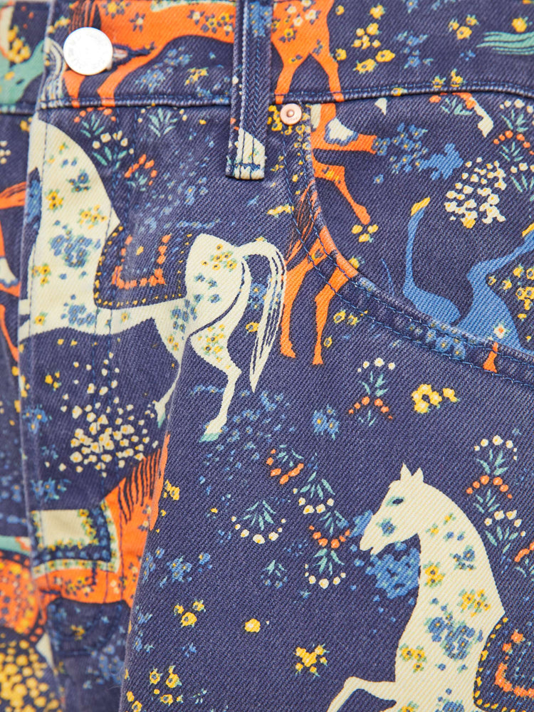 Swatch view of a woman in navy folk art jeans sit lower on the hips with a long 30-inch inseam, button fly, clean hem and slightly tapered leg. 