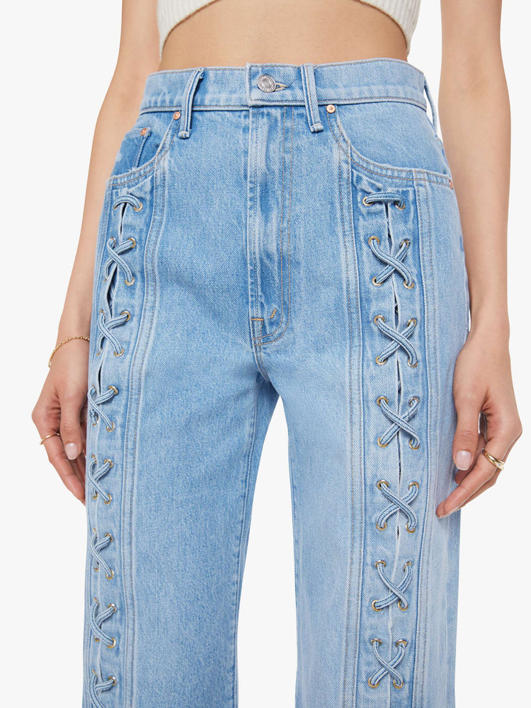 Hem view of a woman in a light blue super high-rise jeans with a loose fit and a wide leg with tied details down the front, a zip fly and 32-inch inseam with a clean hem.