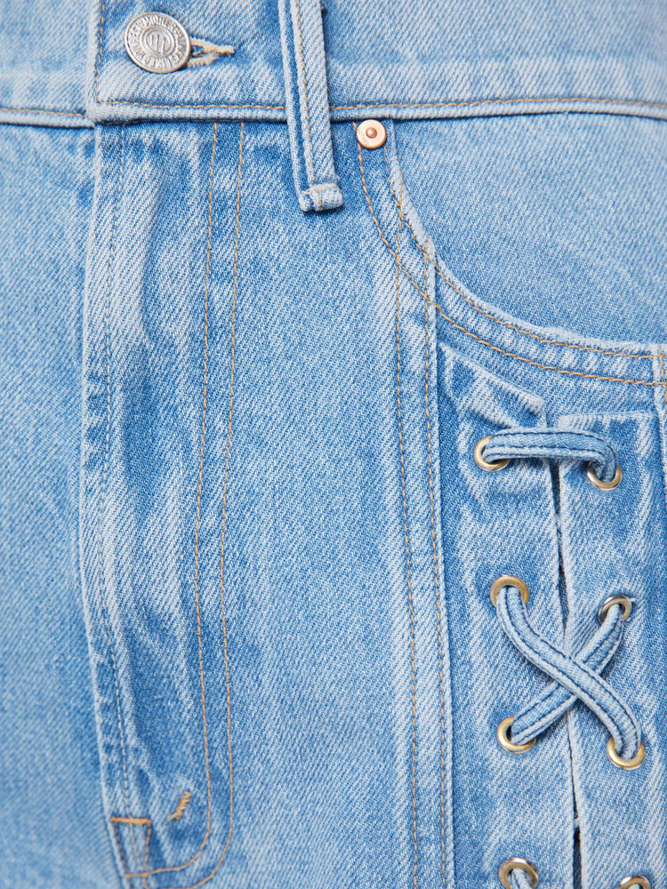 Swatch view of a woman in a light blue super high-rise jeans with a loose fit and a wide leg with tied details down the front, a zip fly and 32-inch inseam with a clean hem.