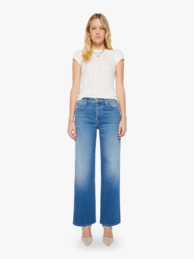 Front view of a woman in a mid blue high-waisted wide leg jeans with a button fly, a long 32-inch inseam and loose, low-slung fit.