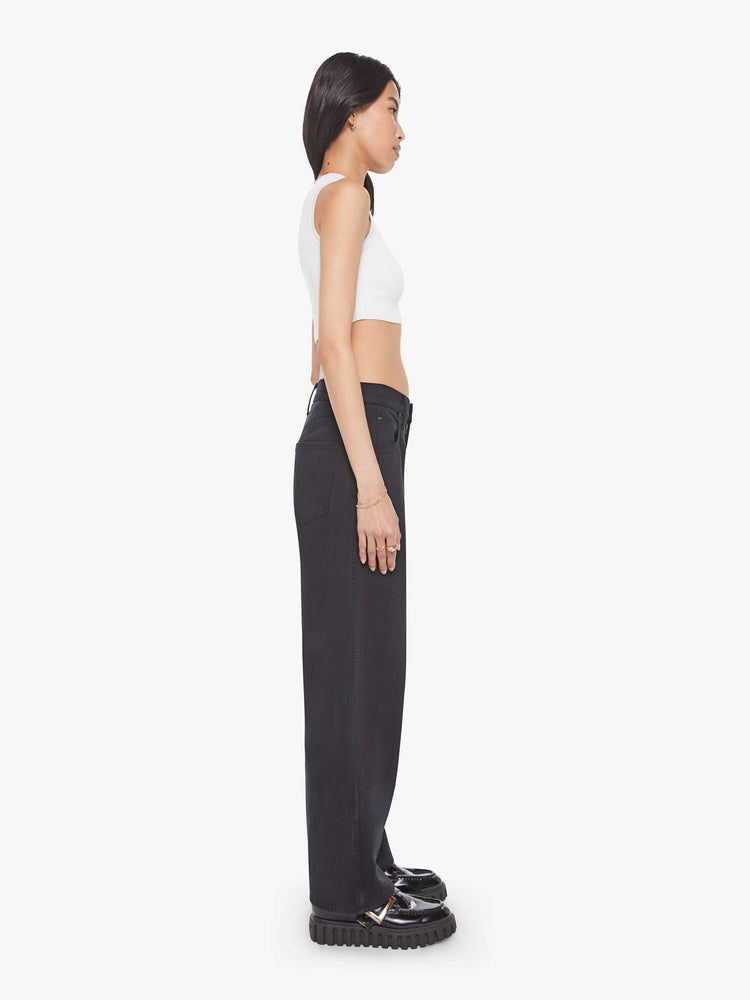 Side view of a woman in a black jeans designed to sit lower on the hips with a 28.5-inch inseam, zip fly, clean hem and slightly tapered leg.