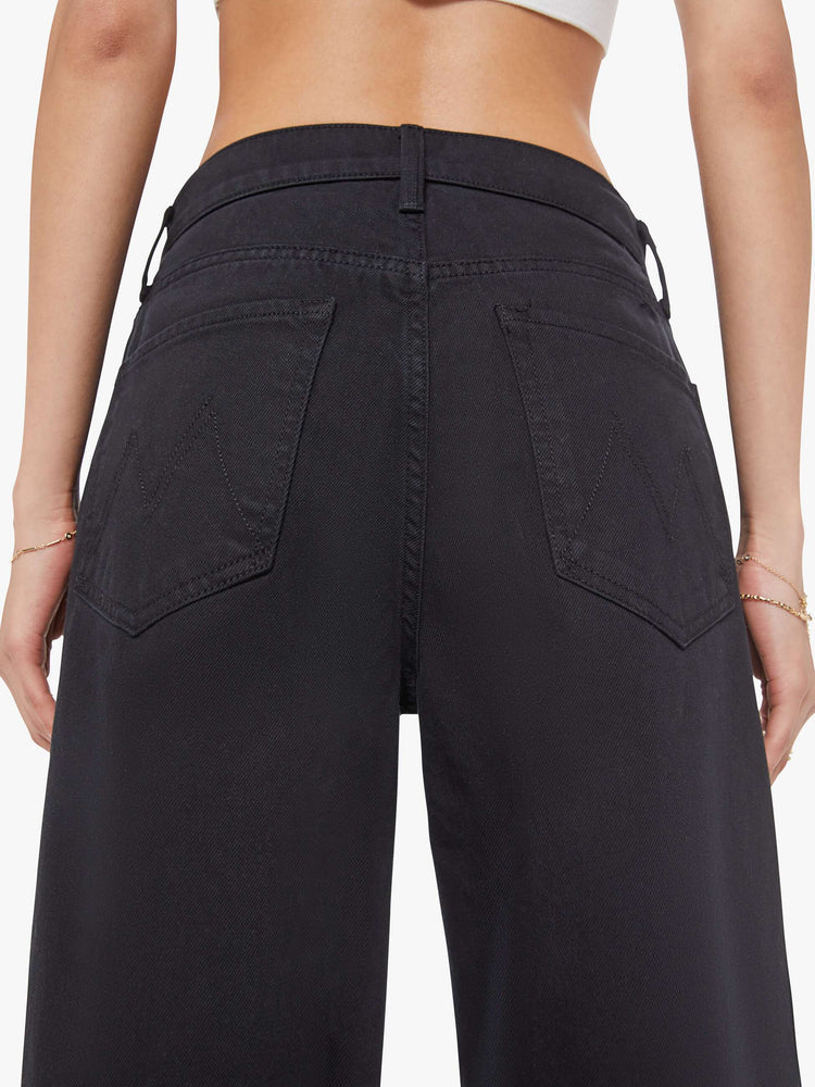 Close up view of a woman in a black jeans designed to sit lower on the hips with a 28.5-inch inseam, zip fly, clean hem and slightly tapered leg.