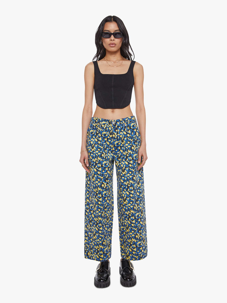Front view of a woman in lower on the hips  jean with an ankle-length inseam, zip fly, clean hem and slightly tapered leg in a a blue, yellow and black leopard print.