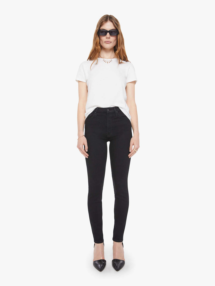 Front view of a woman in a black skinny with a high rise with a 29-inch inseam and a clean hem.