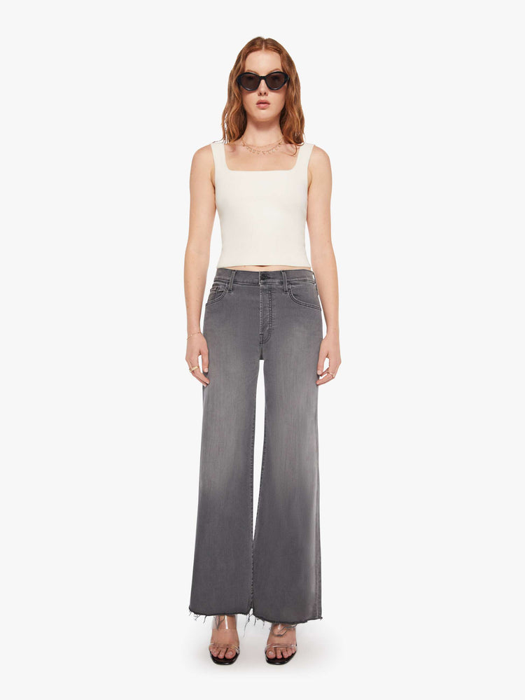 Front view of women's grey high waisted wide leg jean with a frayed hem.