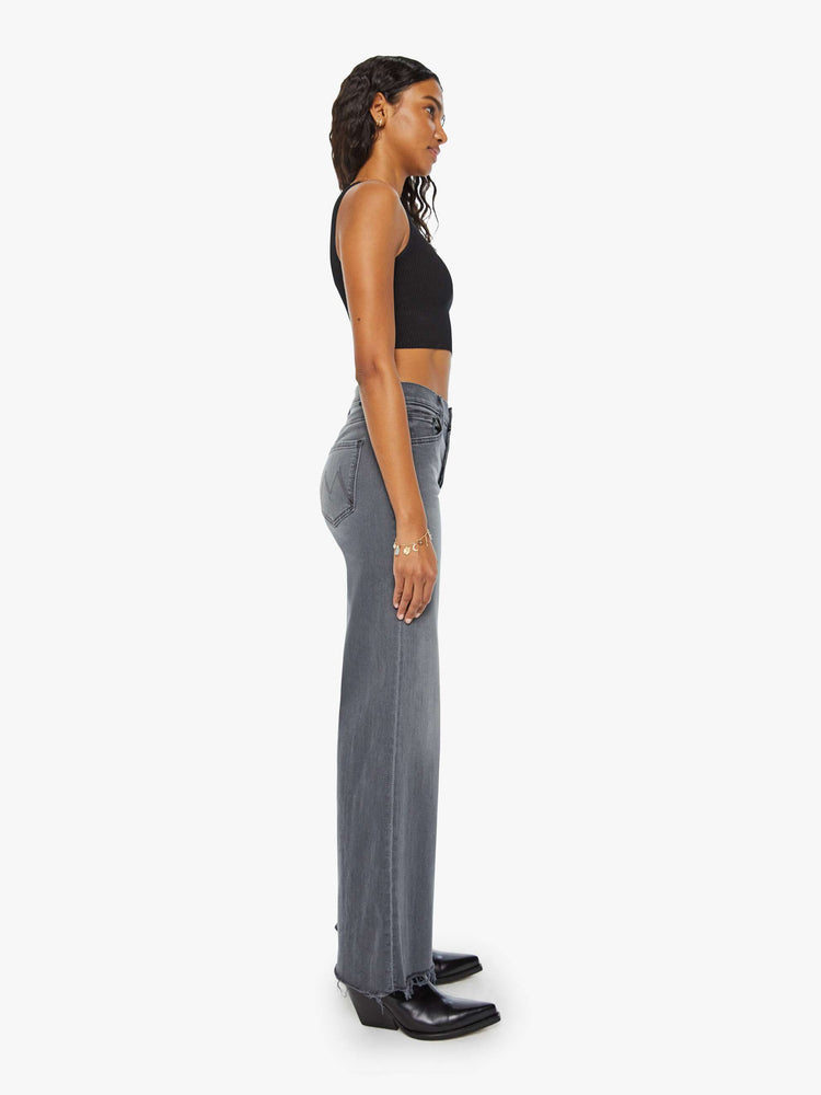 Side view of women's grey high waisted wide leg jean with a frayed hem