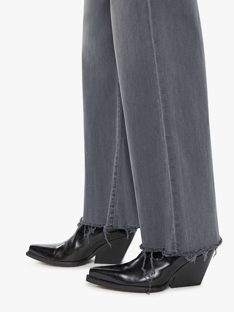 Detail view of women's grey high waisted wide leg jean with a frayed hem
