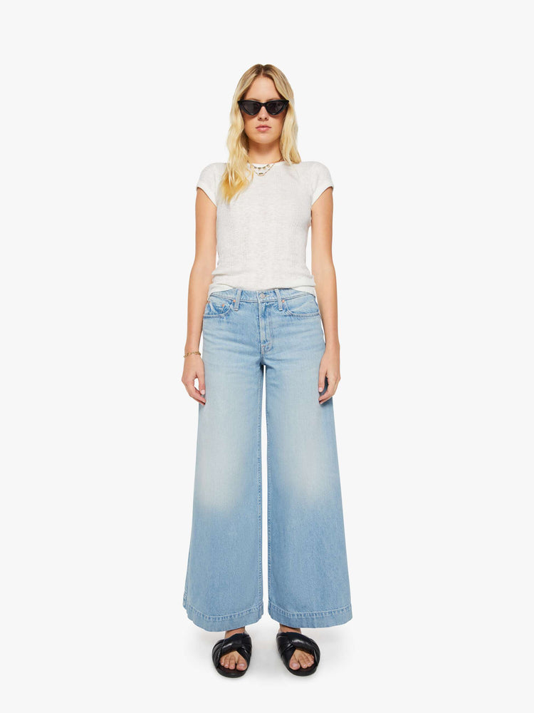 Front view of a woman in a light blue mid-rise wide-leg jeans with a zip fly, long 32-inch inseam and a clean, wide hem.
