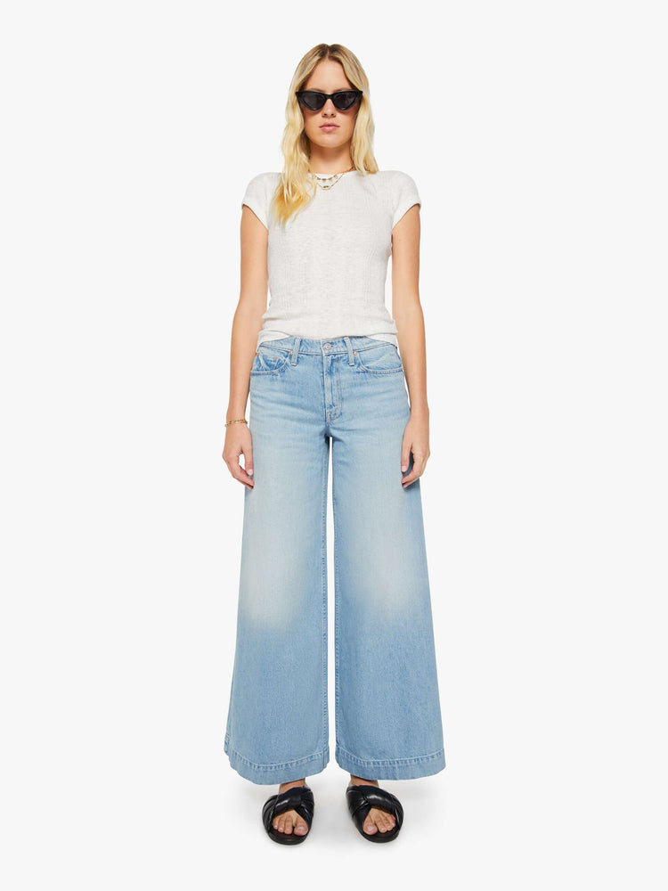 Front view of a woman in a light blue mid-rise wide-leg jeans with a zip fly, long 32-inch inseam and a clean, wide hem.