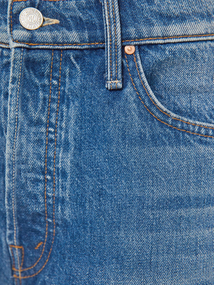 Swatch view of a woman in a med blue jeans designed to sit on the hips with a slouchy fit, a loose straight leg, button fly and a 28.5-inch inseam with a clean hem.