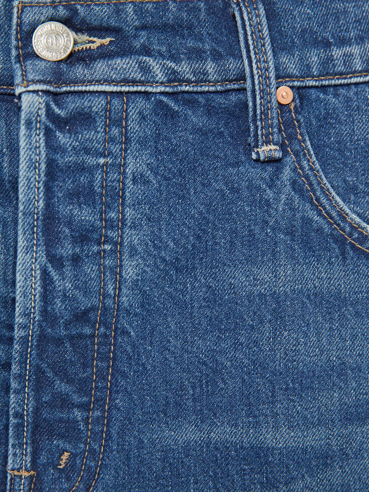 Swatch view of a woman in a mid blue jeans designed to sit lower on the hips with an ankle-length inseam, button fly, clean hem and slightly tapered leg. 
