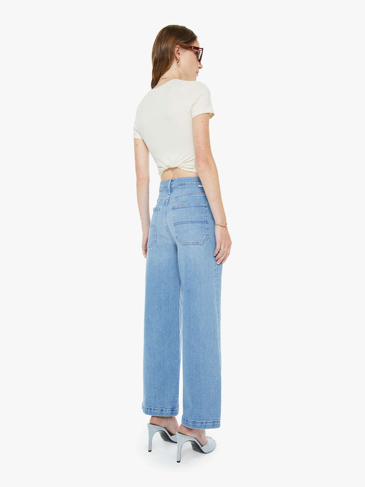 Back view of a woman in a light blue super high-waisted pants with a loose, straight leg, zip fly, utility-inspired patch pockets, hammer loop and an ankle-length inseam with a clean hem.