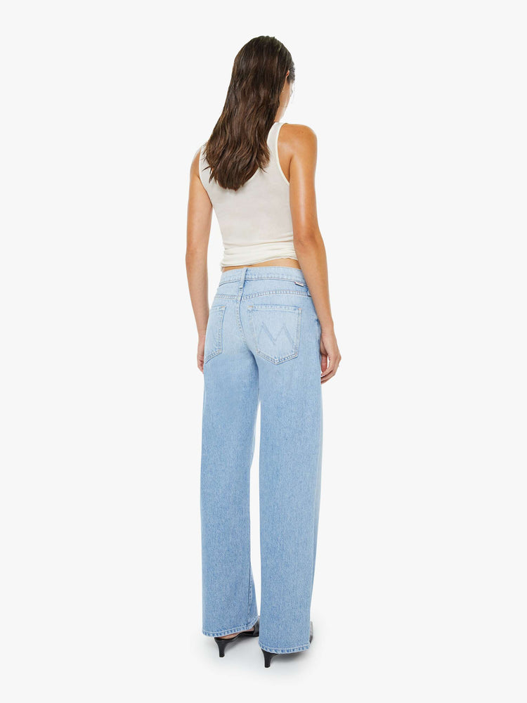 Back view of a woman in a light blue mid-rise jeans have a long 32-inch inseam and a clean hem.