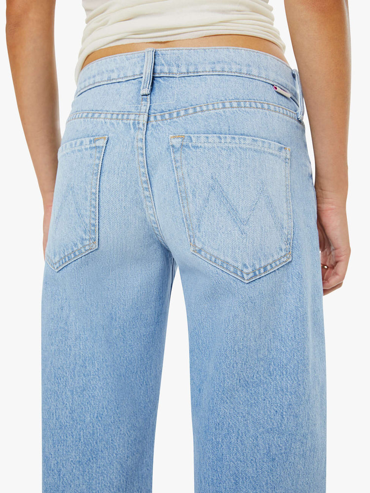 Close up view of a woman in a light blue mid-rise jeans have a long 32-inch inseam and a clean hem.