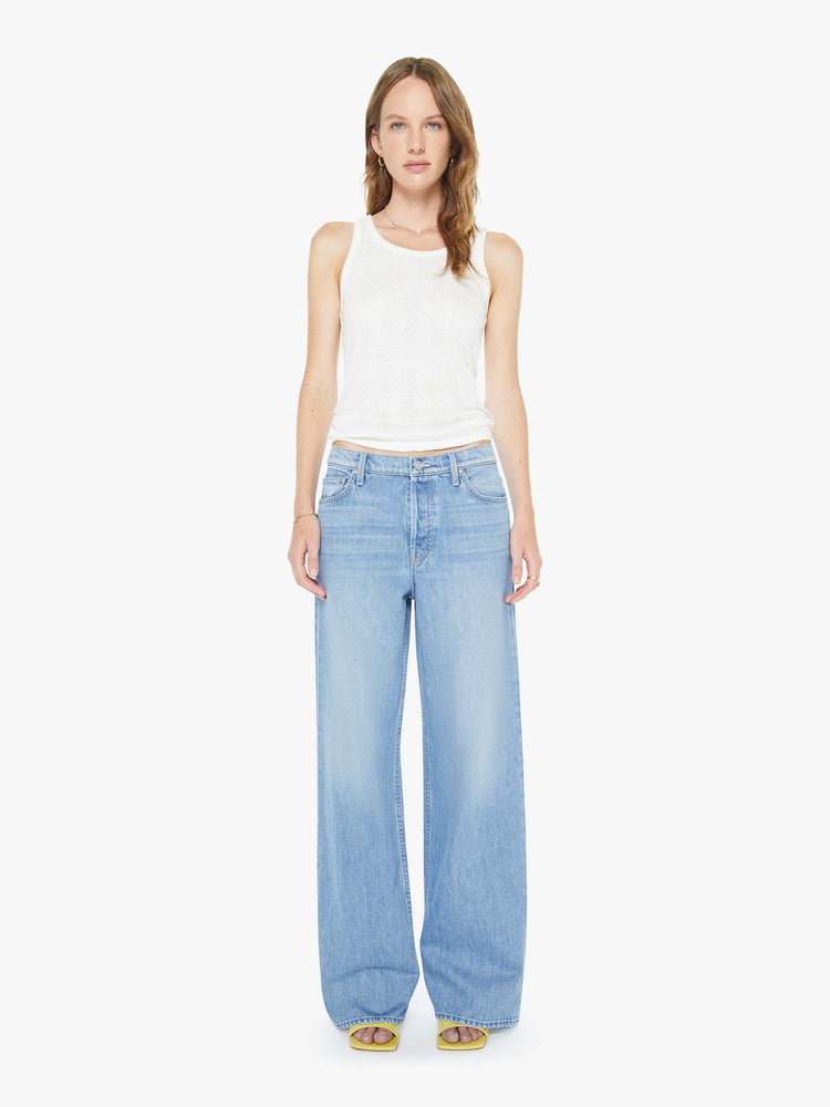 Front view of a woman in a light blue high-waisted wide leg jeans with a zip fly, a long 32-inch inseam and loose, low-slung fit.