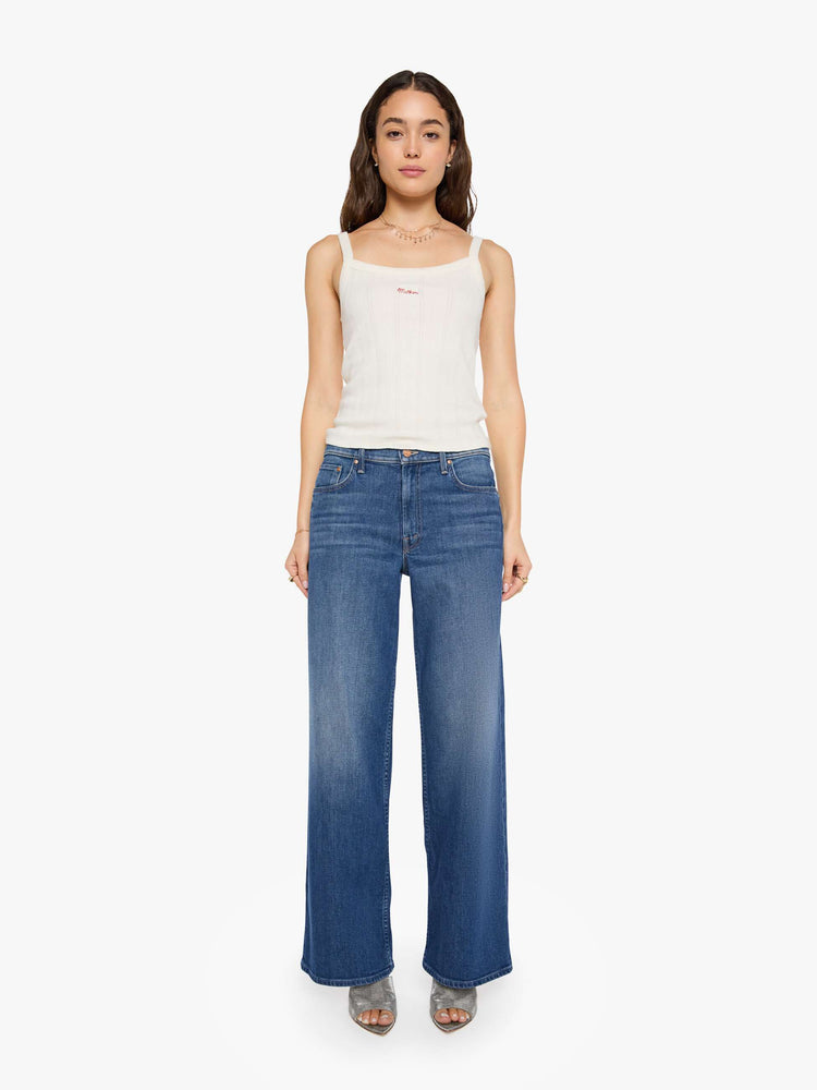 Front view of a woman in a mid blue high-waisted wide leg jeans with a zip fly, 33-inch inseam and loose, low-slung fit.