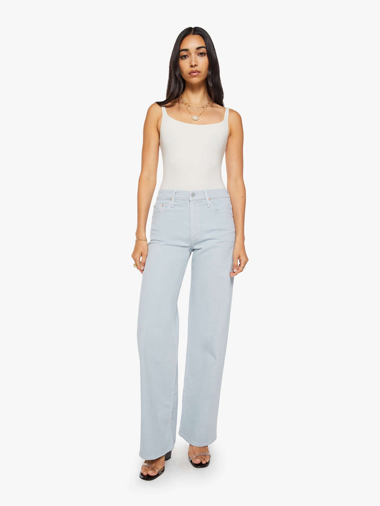 Front view of a woman in a light blue high-waisted wide leg jeans with a zip fly, long 33 1/4-inch inseam and loose, low-slung fit.