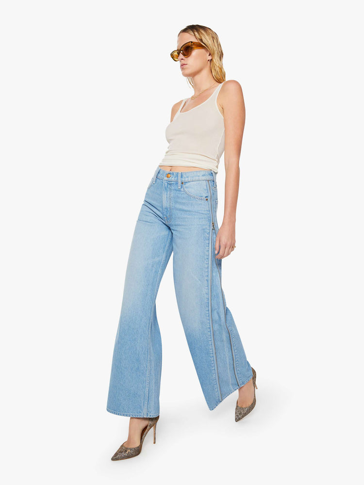 Walking view of a woman in a low-slung jeans can be worn two ways with a zipper on the outer seam that can be closed for a more narrow fit, and are designed with a zip fly, loose, wide leg and a long 32-inch inseam with a clean hem. 