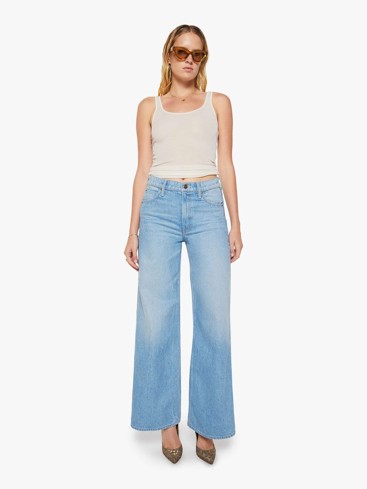 Front view of a woman in a low-slung jeans can be worn two ways with a zipper on the outer seam that can be closed for a more narrow fit, and are designed with a zip fly, loose, wide leg and a long 32-inch inseam with a clean hem. 