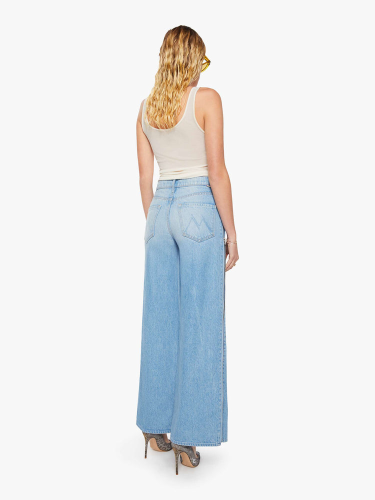 Back view of a woman in a low-slung jeans can be worn two ways with a zipper on the outer seam that can be closed for a more narrow fit, and are designed with a zip fly, loose, wide leg and a long 32-inch inseam with a clean hem. 